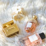 A collection of elegant perfume bottles arranged on a plush fur surface, showcasing luxury and sophistication.